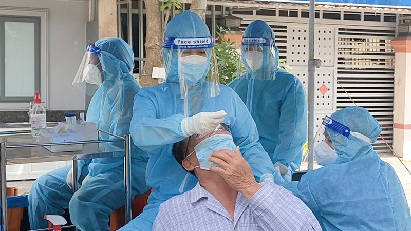 A medical worker collects the sample of a Dong Thap resident to test for coronavirus.