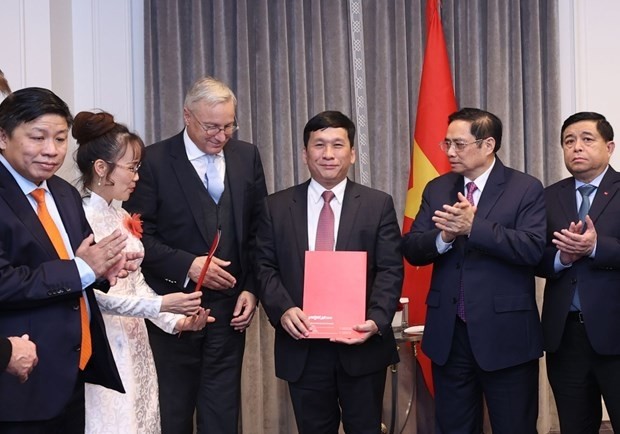 Prime Minister Pham Minh Chinh (second, right) witnesses the signing of the strategic partnership agreement between Vietjet and Airbus. (Photo: VNA)