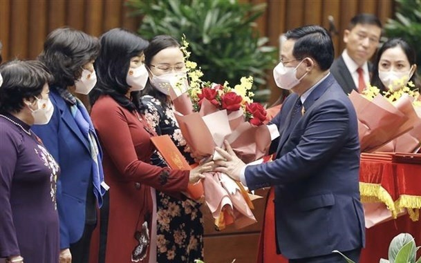 NA Chairman Vuong Dinh Hue presents flowers to the Group of female NA deputies. (Photo: VNA)