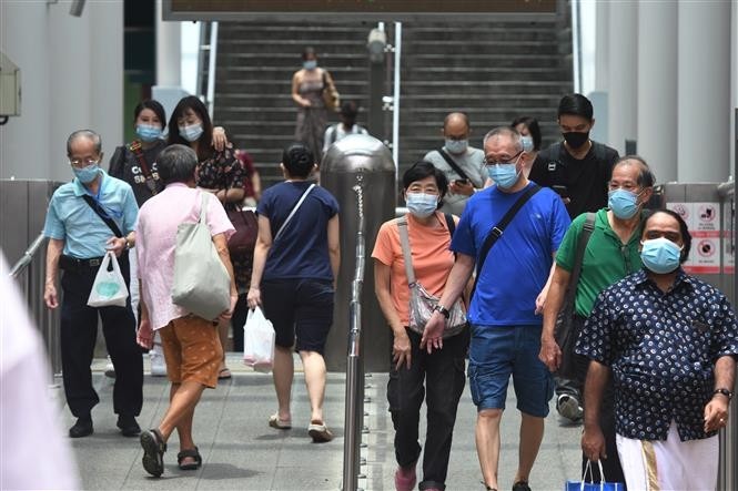 Singaporeans wear masks at a metro station. (Photo: Xinhua/VNA)
