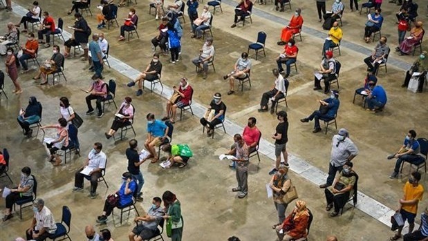 People wait in line to get vaccinated against COVID-19 in Kuala Lumpur, Malaysia, on May 31, 2021. (Photo: AFP/VNA)