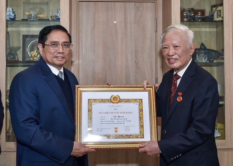  Prime Minister Pham Minh Chinh (L) presents 60-year Party membership badge to former Deputy Prime Minister Vu Khoan (Photo: VGP)