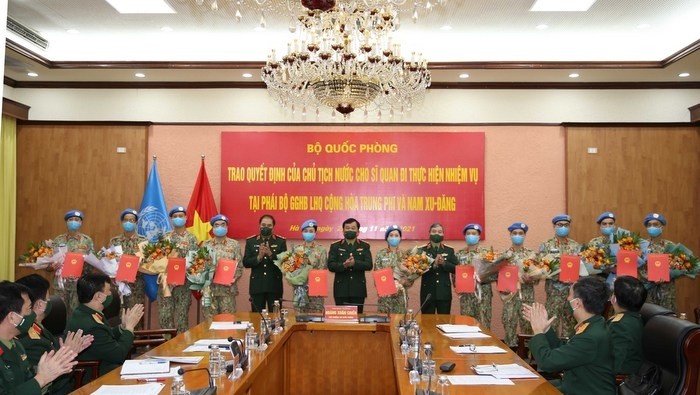 Senior Lieutenant General Hoang Xuan Chien presents the President’s decisions to 12 officers. (Photo: VNA)