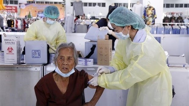 A health worker gives a COVID-19 shot to a senior citizen in Vientiane (Photo: VNA)