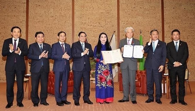 Prime Minister Pham Minh Chinh (fourth from left) witnesses handover ceremony of cooperation agreement between Vinh Phuc and Tochigi (Photo: VNA)