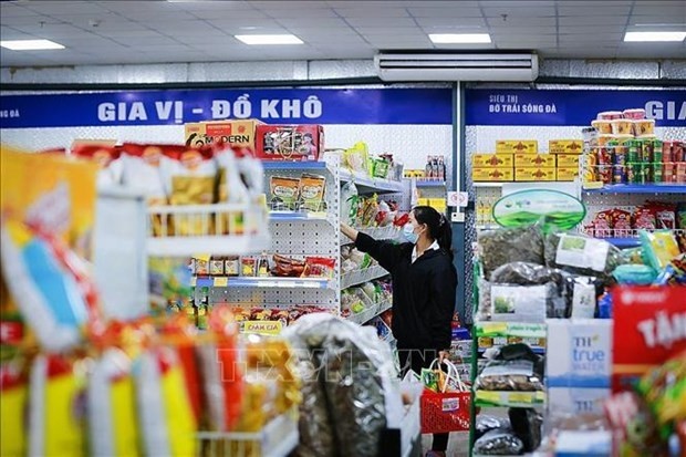 A woman chooses products at a store. (Illustrative photo: VNA)