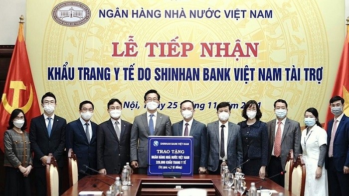 Deputy Governor of the State Bank of Vietnam, Dao Minh Tu receives a token of 320,000 medical masks worth 4.5 billion VND from Shinhan Bank Vietnam General Director Lee Taekyung.