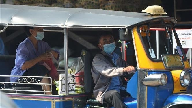 People wear masks to prevent the spread of COVID-19 in Bangkok, Thailand. (Photo: Xinhua/VNA)