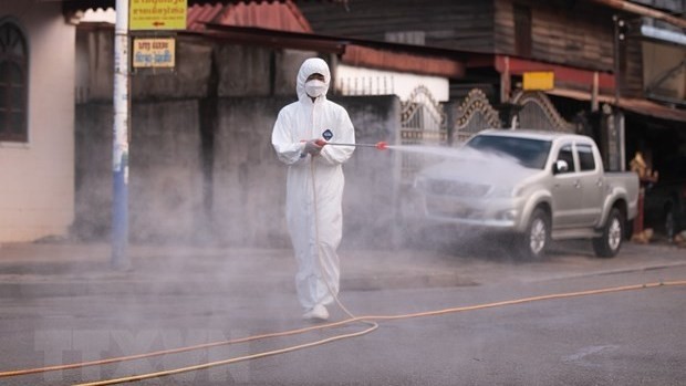 A health worker is spraying disinfectant to prevent the spread of COVID-19 in Vientiane, Laos. (Photo: Xinhua/VNA)