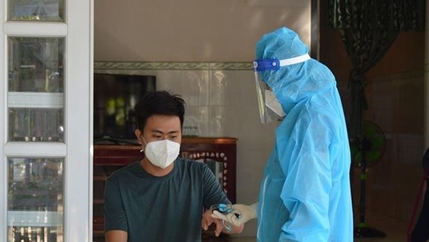 A medical employee checks health for a COVID-19 patient who is treated at home in Thanh Binh District of southern Dong Thap Province. 