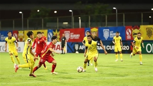 Nguyen Cong Phuong (No.10 in red) fooled three defenders with his close control and dribbling before unleashing a superb finish past Malaysian goalie (Photo: VNA)