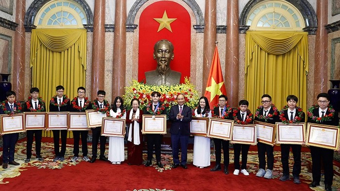 President Nguyen Xuan Phuc and former Vice President Nguyen Thi Doan present Labour Orders to outstanding winners of international olympiads. (Photo: NDO)