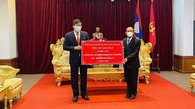 Vietnam’s Consul General in Luang Prabang Nguyen Dang Hung (L) hands over Quang Ninh's aid to Luang Prabang on December 31 (Photo: VNA)