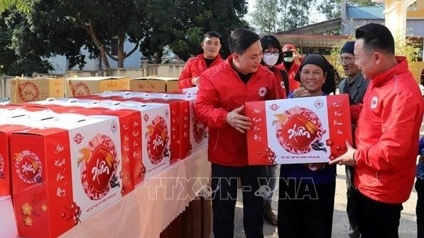 Members of the Vietnam Red Cross Society present Tet gift sets to beneficiaries. (Photo: VNA)
