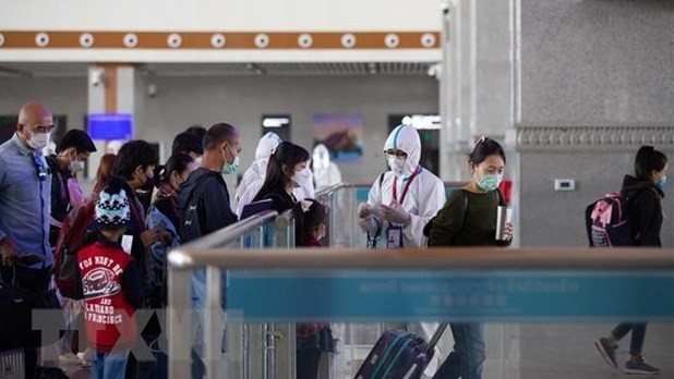 People are seen wearing masks at a train station in Vientiane. (Photo: Xinhua/VNA)
