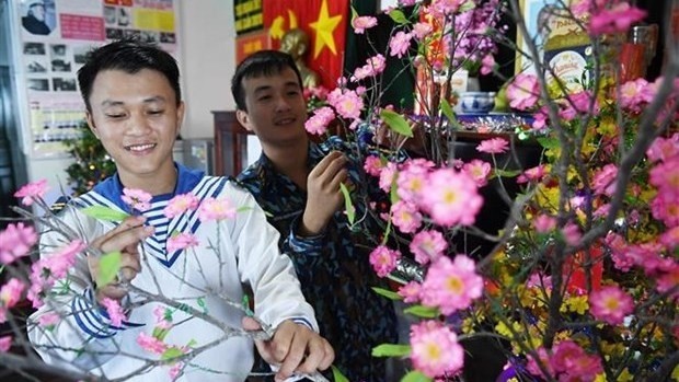 Soldiers on DK1.10 platform decorate a peach blossom branch to welcome the 2021 Lunar New Year (Photo: VNA)