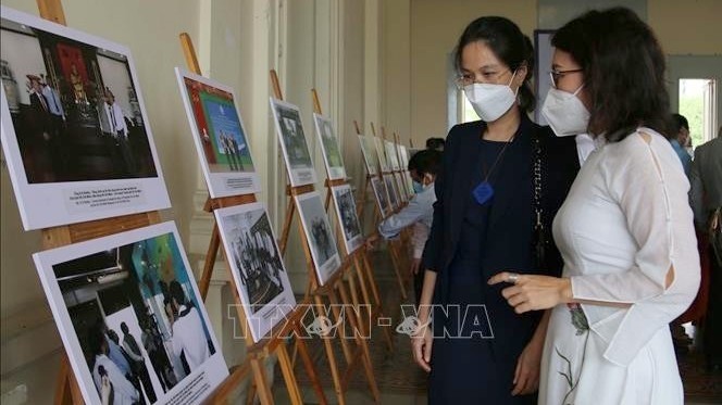 Visitors admiring photos on display at the exhibition. (Photo: VNA)