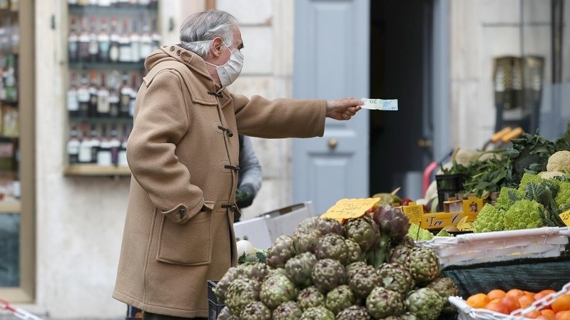 A man shops for groceries at an open-air market as the government is due to announce stricter coronavirus disease (COVID-19) restrictions, in Rome, Italy, March 12, 2021. (Photo: Reuters)