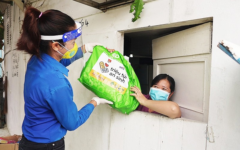 A youth union member provides a "welfare bag" to a local in Ho Chi Minh City.