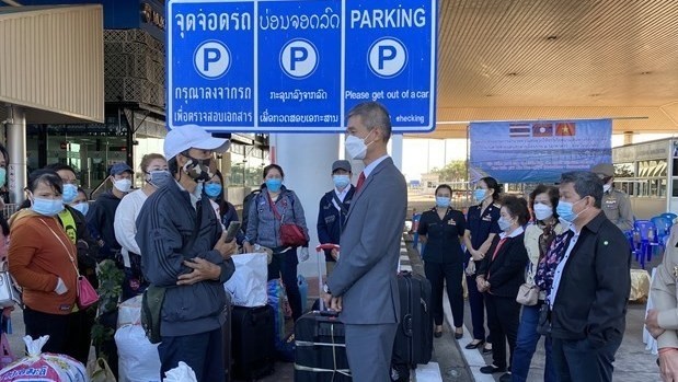 On the morning of January 12, about 60 Vietnamese people with difficult circumstances living and working in the Northeastern region of Thailand return to Vietnam by road. (Photo: VNA) 