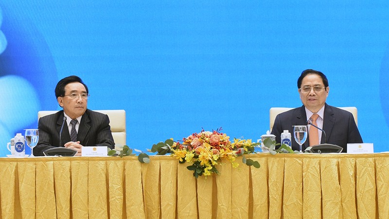 Vietnamese Prime Minister Pham Minh Chinh (R) and his Lao counterpart Phankham Viphavanh at a meeting with Vietnamese and Lao enterprises in Hanoi on January 10. (Photo: NDO/Tran Hai)