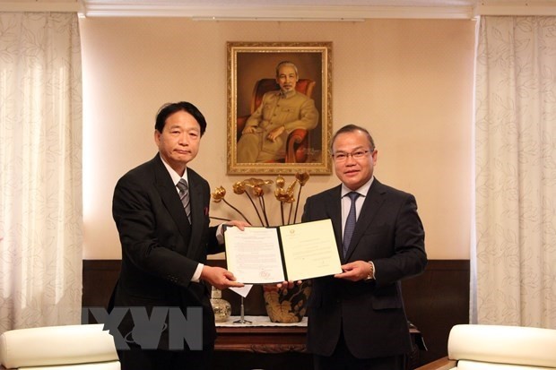 Vietnamese Ambassador to Japan Vu Hong Nam (R) hands over the decision to Prof. Dr. Nagato Natsume. (Photo: VNA)