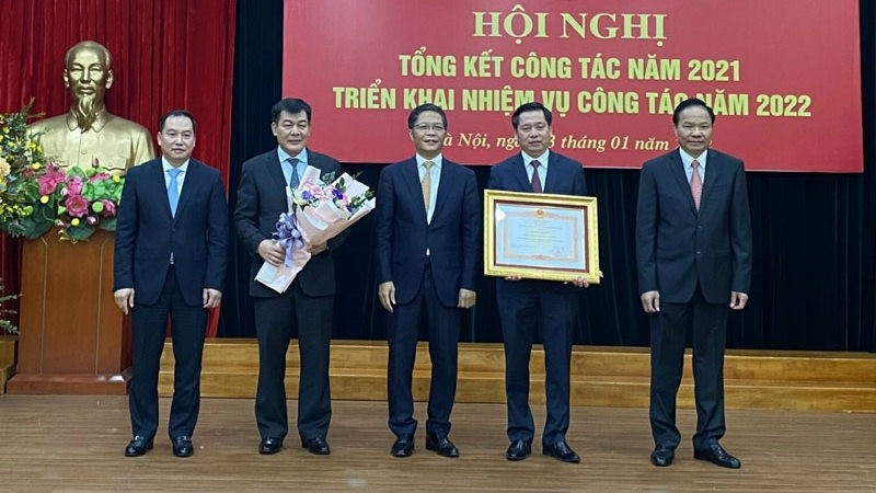 Head of the Central Economic Commission Tran Tuan Anh presents a certificate of merit to the bloc's Party Committee.