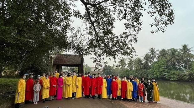 Foreign diplomats in "ao dai" (the traditional costume of Vietnam) pose for a photo when visiting Duong Lam village on January 23 (Photo: VNA)