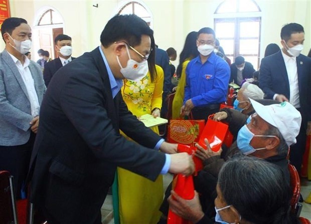 NA Chairman Vuong Dinh Hue presents Tet gifts to poor and near-poor households and social policy beneficiaries in Nghe An. (Photo: VNA)