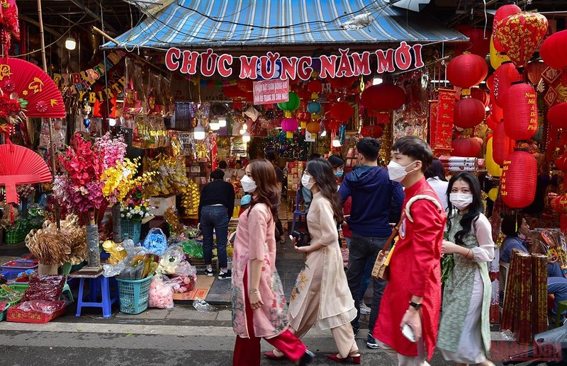Young people dressed in 'Ao Dai walk on Hang Ma Street to enjoy the atmosphere and shop for Tet (Photo: NDO/Thanh Dat)