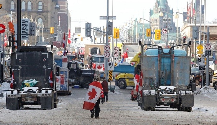 A person walks by trucks blocking roads downtown as truckers and their supporters continue to protest coronavirus disease (COVID-19) vaccine mandates, in Ottawa, Ontario, Canada, February 7, 2022. (Photo: Reuters)
