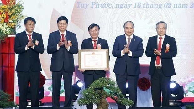 President Nguyen Xuan Phuc (second from right) presents a certificate recognising Tuy Phuoc a new-style rural area. (Photo: VNA)