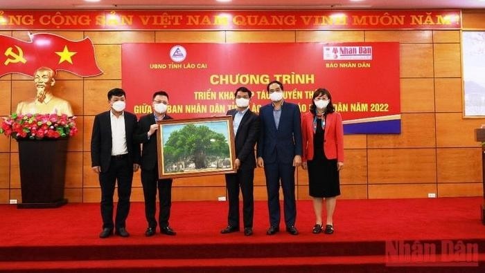 Editor-in-chief of Nhan Dan Newspaper Le Quoc Minh presents the picture of the banyan tree to Lao Cai province. (Photo: NDO)