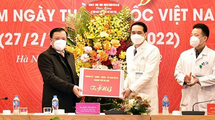 Secretary of the Hanoi Party Committee Dinh Tien Dung (L) presents a gift to the Saint Paul General Hospital on February 21. (Photo: hanoimoi.com.vn)