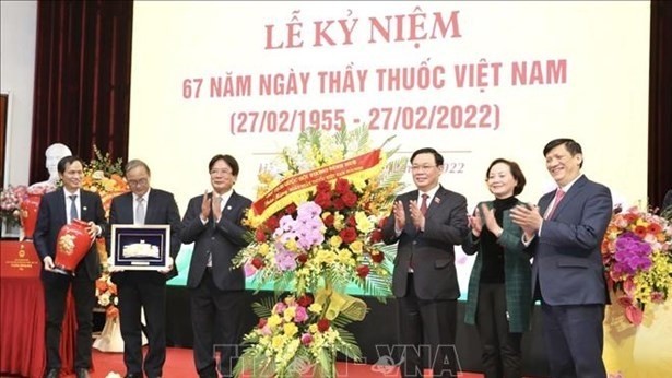 NA Chairman Vuong Dinh Hue (third, right) presents flowers to the Viet Duc University Hospital on the occasion of the 67th Vietnamese Doctors' Day 