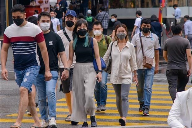 People wear masks to prevent the COVID-19 pandemic in Kuala Lumpur, Malaysia on February 24. (Photo: XINHUA/VNA)