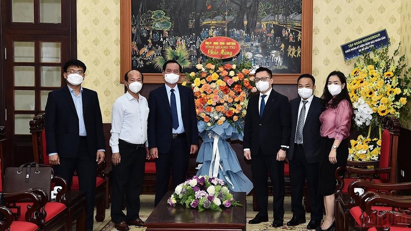 Quang Tri Chairman Vo Van Hung presents flowers to Nhan Dan, congratulating the newspaper on the 71st anniversary of its first issue. (Photo: Thuy Nguyen)