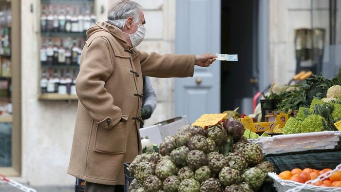 A man shops groceries at an open-air market in Italy. (Photo: Reuters)