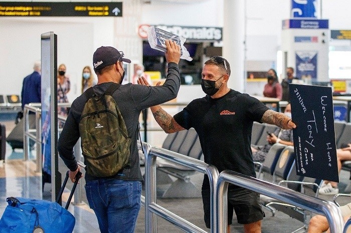 Passengers and loved ones reunite at the arrivals hall on the first day of New Zealanders returning from Australia after the border reopened for travellers observing home self-isolation rules, at the Auckland international airport on Feb 28. (Photo: AFP)