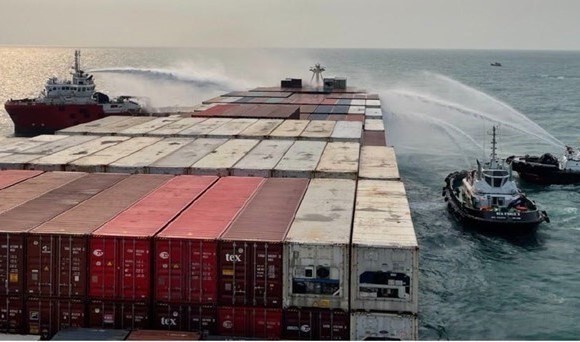Vietnamese forces spray water to put out fire on the container ship (Photo: VNA)