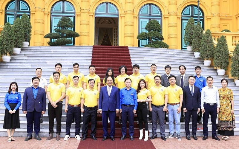 President Nguyen Xuan Phuc (third, left) and the outstanding young people pose for a group photo. (Photo: VNA)