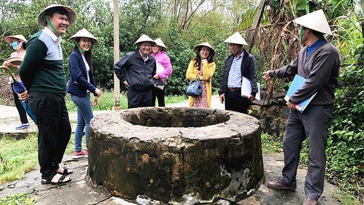 Tourists visit an ancient well in Go Co village (Photo: NDO/Nguyen Le)
