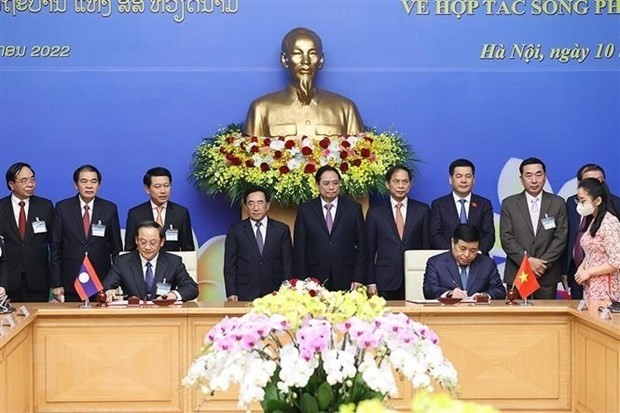 Prime Minister Pham Minh Chinh and Lao Prime Minister Phankham Viphavanh witness the signing of the Vietnam-Laos cooperation agreement for 2022. (Photo: VNA)
