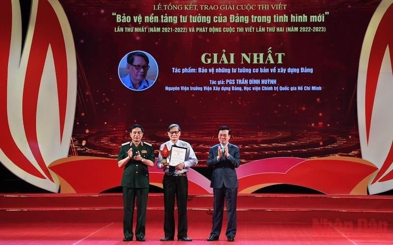 Permanent member of the Party Central Committee’s Secretariat Vo Van Thuong and Minister of Defence Gen. Phan Van Giang present the first prize to Assoc. Prof. Dr. Tran Dinh Huynh.