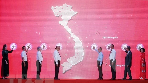 President Nguyen Xuan Phuc (fourth from left) and delegates launch the Humanitarian Month (Photo: VNA)