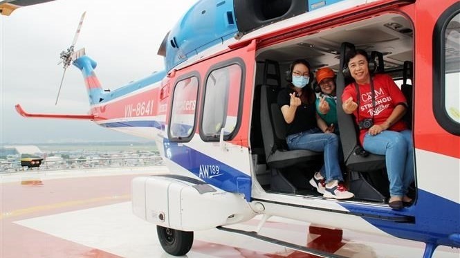 Passengers aboard a sightseeing helicopter. (Photo: VNA)