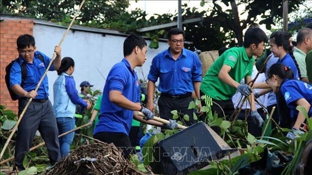 Young people take part in an environmental cleanup programme. (Photo: VNA)