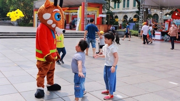Children interacting with Saola, the mascot of SEA Games 31, at Hanoi Tourism Gift Festival 2022. (Photo: NDO/Giang Nam)