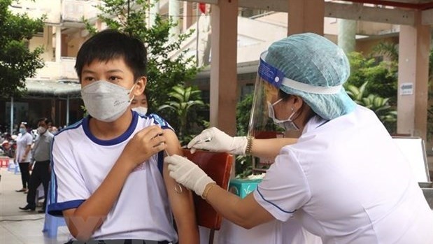 A health worker administers COVID-19 vaccine to a sixth grader at the Le Quy Don Secondary School in Vinh Long city, Vinh Long province. (Photo: VNA)