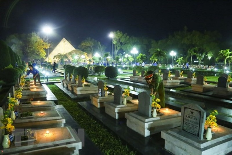 The young generation lights candles to pay tribute to the fallen heroes on historical land. (Photo: VNA)